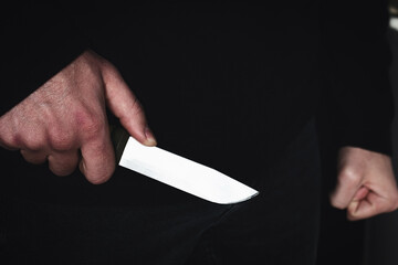 robber killer criminal with a knife in hand close up