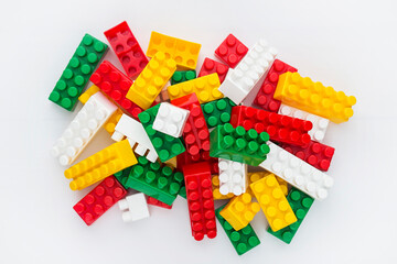 Plastic building toy blocks on white background. Pile of colorful childrens building bricks on white background