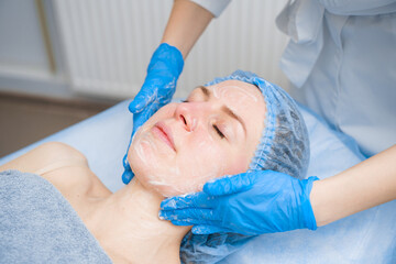 Obraz na płótnie Canvas Spa procedure. Facial massage and spreading cream. Cosmetic skin care