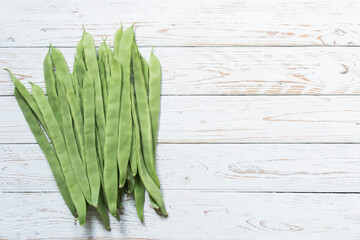 runner beans on a white wooden board. copy for space and text
