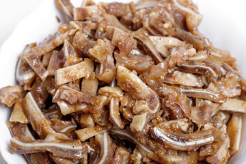 Appetizing beer snack - smoked pork pig ears on a board on a gray background
