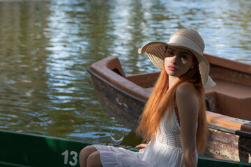 Ragazza rossa con capello sul sulla barca 