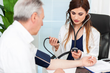 Doctor using a stethoscope and a sphygmomanometer to check blood pressure