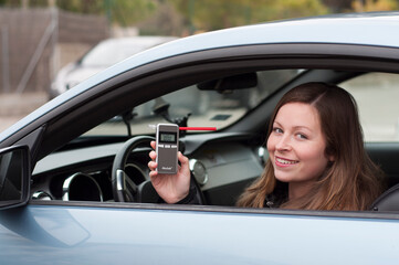 drink and drive young female driver being subject to test for alcohol content with use of breathalyzer. she is smiling as she does not drive and drink