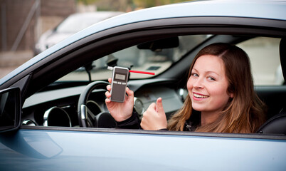 drink and drive young female driver being subject to test for alcohol content with use of...