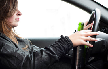 drink and drive crashed female driver with a bottle of wine - do not drink and drive concept