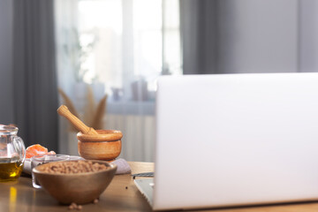 Someone cooking using the computer to watch virtual culinary class