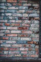 Old red brick wall, rough texture outdoors, weathered surface close-up, vertical photography.