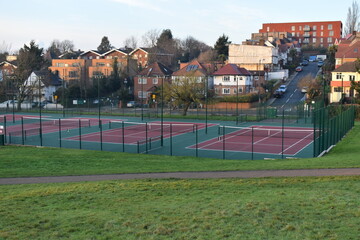An outdoor macadam pay as you play tennis court open to the public in the UK Hard courts are made of uniform rigid material covered with an acrylic surface layer to offer greater consistency of bounce