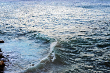 Fototapeta premium A glimpse of a blue sea that breaks on the rocks along the shore. South Tyrrhenian Sea.