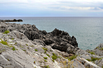 Fototapeta na wymiar The typical jaggy rocky coast of the Cilento, a mountainous area of southern Italy. Tyrrhenian Sea. 