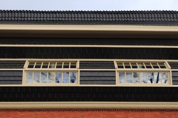 Facade Detail with Black Tiles, Red Bricks and Windows of a School of Amsterdam Architecture Building in Amsterdam
