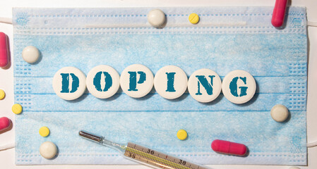 The word doping written with pills on a wooden background