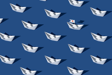 Fototapeta premium Love boat. Creative pattern made with paper boats against blue background.