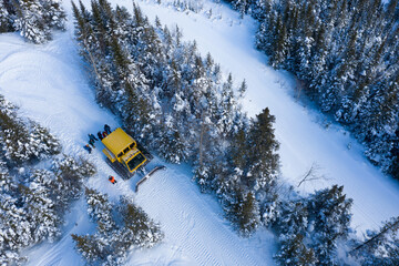 Aerial drone photo of a group of skiers and snowboarders in a snow cat in the Chic Choc Mountains of Quebec, Canada