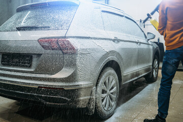 Application of first phase on dirty auto. Foam covering car at car wash. Car Detailing.