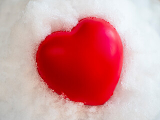 Hot heart lies on the white snow and melts it up, Concept of love, passion, Valentine's day