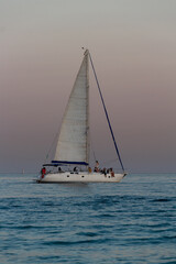 Obraz premium yacht against the background of the pink sky over the sea horizon