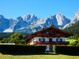 Fototapeta na wymiar An idylic Austrian Tiroler alpine house with dramatic peaks in the background.