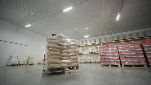 Warehousing. Forklift driver stacking big bag of raw material in warehouse.