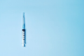 One single medical plastic disposable vaccination syringe with the needle in the cover cap isolated...