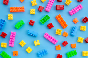 Plastic building blocks on blue background.