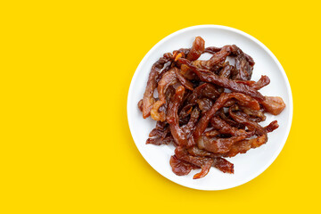Deep fried sun-dried pork on yellow background.