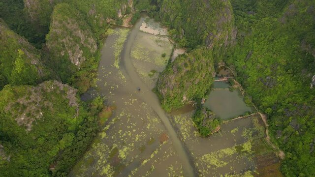 Aerial shot of beautiful limestone mountains with passes carved by a river in Ninh Binh region, a famous tourist destination in northern Vietnam. Travel to Vietnam concept