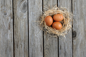 Homemade chicken eggs in a nest on a rustic background. Сopy cpace for your text