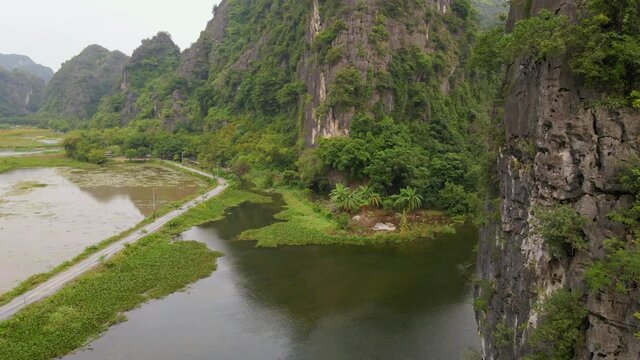 Aerial shot of beautiful limestone mountains with passes carved by a river in Ninh Binh region, a famous tourist destination in northern Vietnam. Travel to Vietnam concept