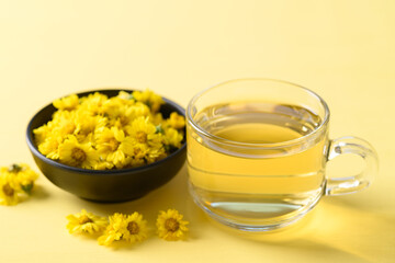 Organic Chrysanthemum flower tea in a cup on yellow background, Healthy Herbal drink