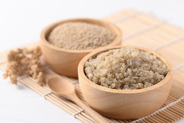 Cooked brown quinoa seeds and raw quinoa seeds in a wooden bowl, Healthy vegan food