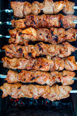 skewered pork kebab grilled over charcoal, smoke over a barbecue, medium cooking, close