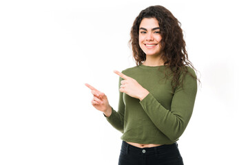 Naklejka premium Happy hispanic woman pointing two fingers to copyspace
