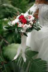 The bouquet is in the hands of the bride.