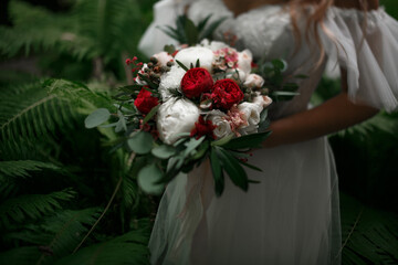 The bouquet is in the hands of the bride.
