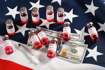American flag, coronavirus vaccine vials, syringe and money for purchase or trading vaccine concept. Top view