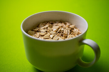 oatmeal inside a white cup with green background