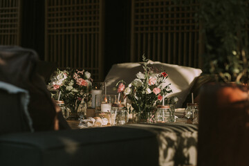 wooden table with personalized glasses, candles and flowers. Decoration for social events.