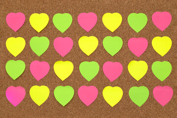 Paper heart shape sticky notes on cork board