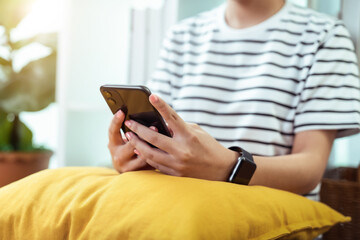 Woman holding a smartphone and using social media on internet.
