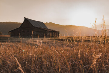 old barn at sunset and teton mountains  - Powered by Adobe