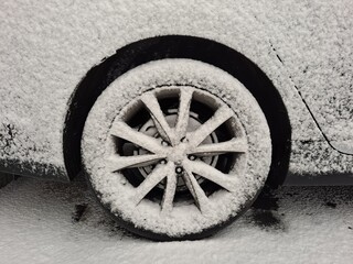 Snow covered ground and car wheels