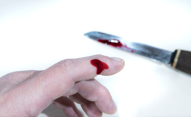 A person cut his finger with a knife and it is bleeding.