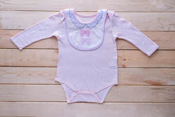 The clothes for kids for babies set with accessories on the wooden table.