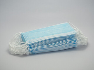 A pile of blue masks. White ear straps on a white background.