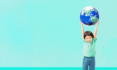 Kid raising world on lighrt blue background, Ecological friendly and corporate social responsibility concept, Element of the image furnished by NASA