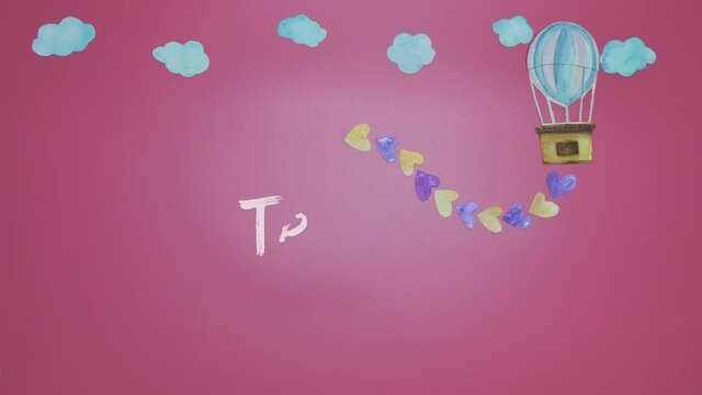 Stop Motion of hand painted paper cut flying air balloon with gold and violet hearts through the sky with moving clouds on pink pastel background with &lsquo;Te Amo&rsquo; or &lsquo;I Love You&rsquo; in Spanish brush stroke.