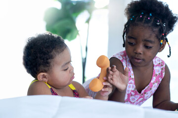 African child girls play on the phone with little friends in the room