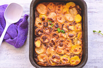 delicious moussaka authentic recipe - layers of eggplant minced beef meat tomato bechamel sauce and cheese baked in oven in gratin dish on old wooden boards